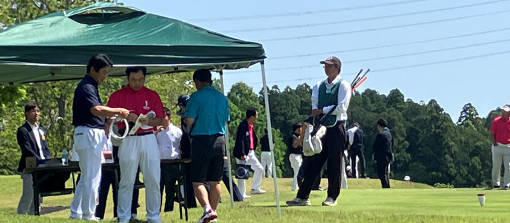 スタート前にティーグラウンドでピンポジションをチェックする選手たち